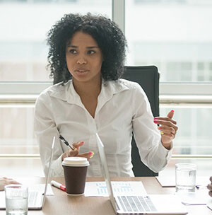 A project management consultant sitting at desk with coffee offering guidance.