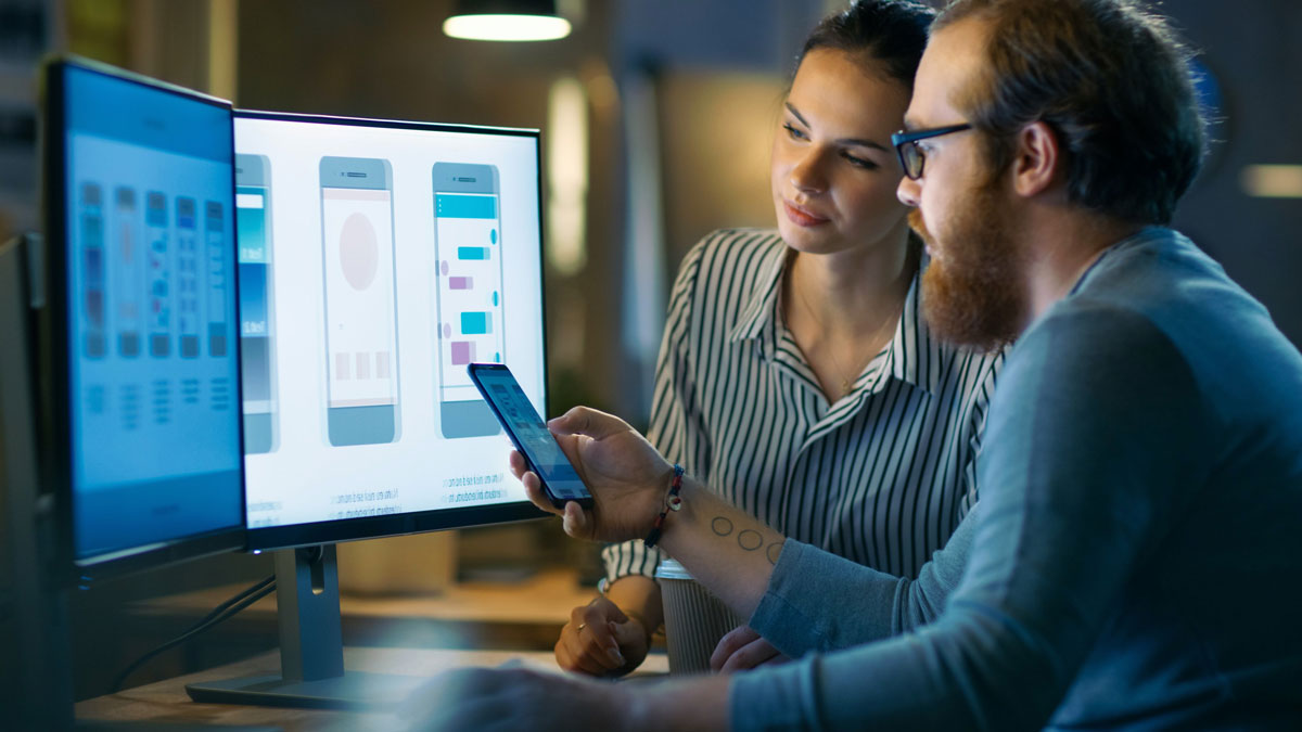 A woman and man work together to design and develop a mobile application.